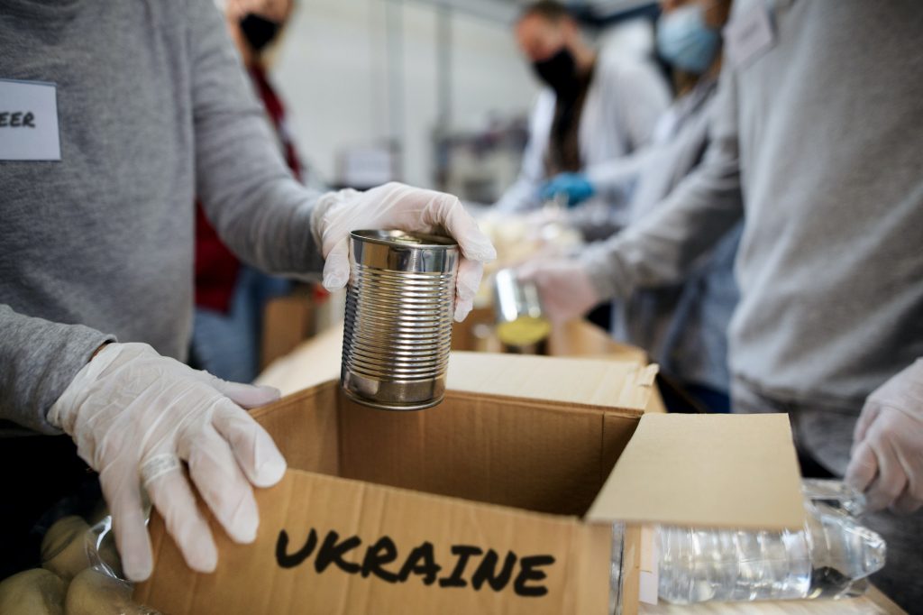 Group of volunteers collect donations for Ukrainian refugees, humanitarian aid concept