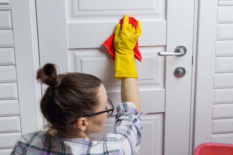 Woman worker in rubber gloves doing cleaning in the bathroom