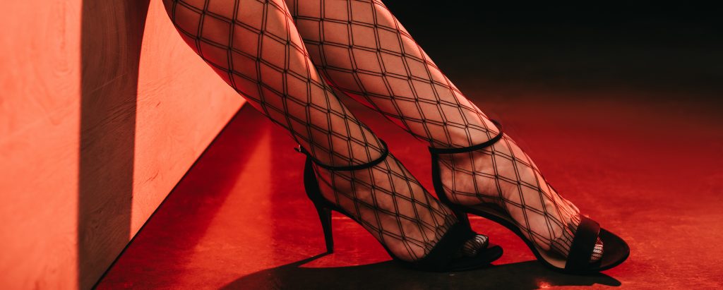 cropped view of prostitute in mesh stockings and heels
